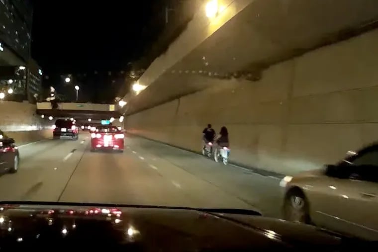 A video captured by a driver's dashcam shows two people using Indego, the city's bike-sharing system, heading westbound on Interstate 676 around 10 p.m.