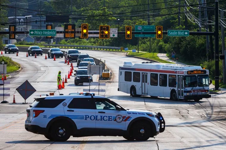 Upper Merion police divert traffic at Saulin Blvd away from the large sink hole in the middle of Dekalb Pike in front of Tires Plus, 152 E. Dekalb Pike in King of Prussia, PA on Tuesday morning July 11, 2023.