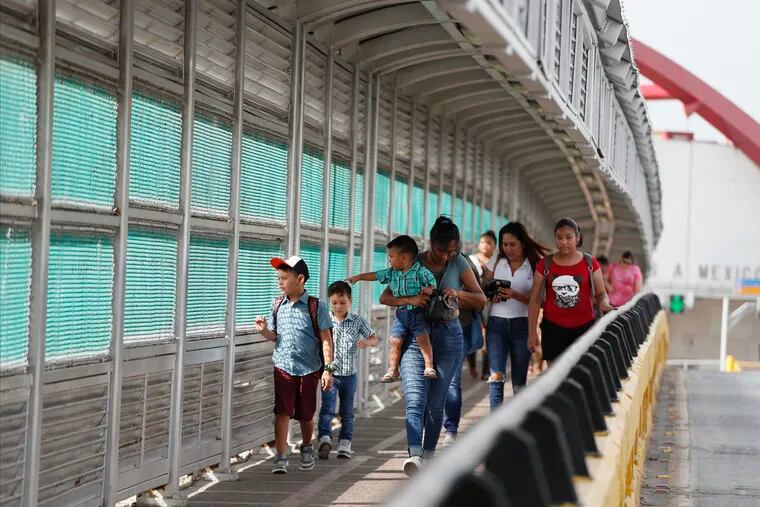FILE - In this June 28, 2019 file photo, local residents with visas walk across the Puerta Mexico international bridge to enter the U.S., in Matamoros, Tamaulipas state, Mexico. A federal judge in Portland, Ore., on Saturday, Nov. 2, 2019, put on hold a Trump administration rule requiring immigrants prove they will have health insurance or can pay for medical care before they can get visas. U.S. District Judge Michael Simon granted a preliminary injunction that prevents the rule from going into effect Sunday.