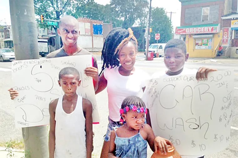 Emsheree Patterson (center) hangs out at 19th Street and Hunting Park Avenue Sunday, Aug. 10, 2014 with daughter Euree, 5, and teens during a charity car wash for her organization, Worry About Nothing Purpose is Alive in Everyone. (Morgan Zalot/Daily News Staff)