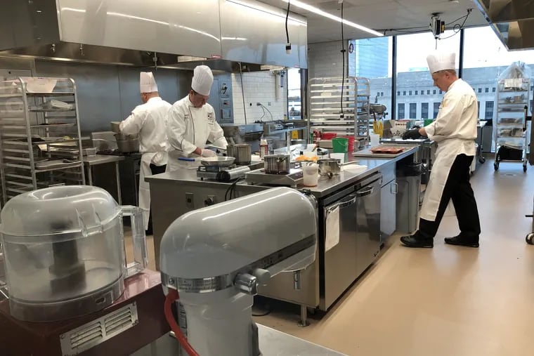 Chefs hustle during the competition in a kitchen at Aramark headquarters at 2400 Market St.