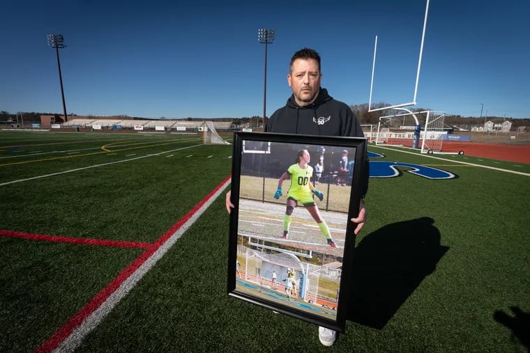 Mike Herman with a photograph of his daughter, Schyler, at Pleasant Valley High School, in the Pocono Mountains, where she played soccer. He wants to know whether artificial turf could be linked to the cancer that killed her at age 15.