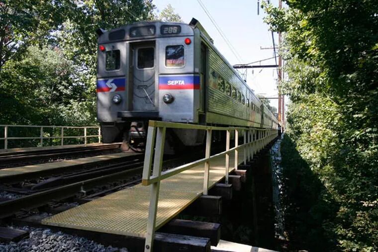 The SEPTA train passes over the bridge over Crum Creek in Swarthmore. (Charles Fox / Inquirer)