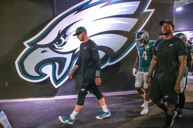 Carson Wentz walks out to the field prior to Thursday's season opener. He was inactive.