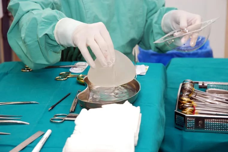 A nurse prepares a textured breast implant for surgery.