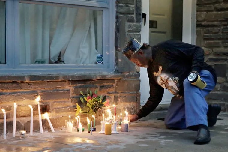 Neighbors and friends light candles at a vigil for Regina Brunner Holmes in front of her home in Mount Airy. (ELIZABETH ROBERTSON/STAFF PHOTOGRAPHER)