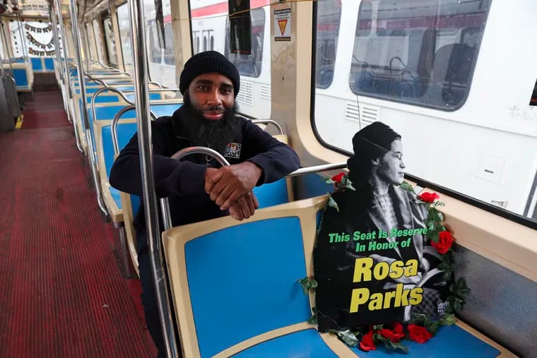 Sumartine Davis poses for a portrait near a Rosa Parks cut out on the decorated 34 trolley for Black History Month, at the SEPTA Elmwood Depot in Philadelphia on Monday, Feb. 26, 2024.