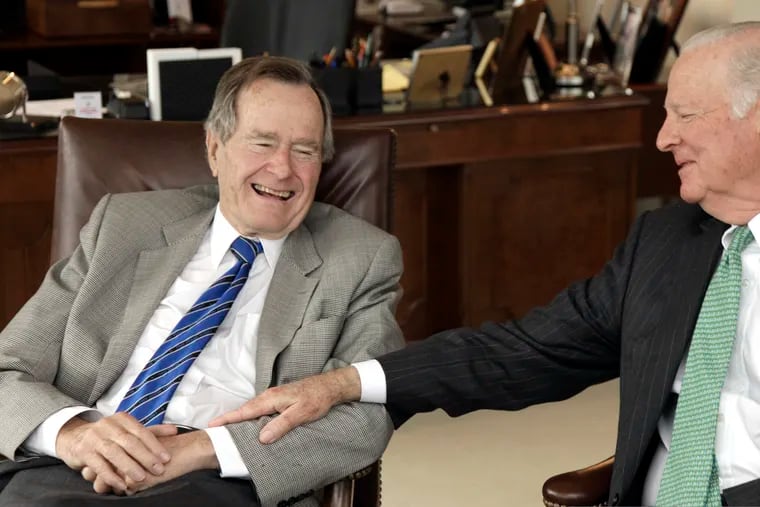 FILE - In this Jan. 18, 2011 file photo, former President George H.W. Bush, left, and former Secretary of State James A. Baker III share a moment as they talk about the Gulf War and liberation of Kuwait, during an interview in Houston.  Bush didn’t lose his sense of humor even as he was letting go of life. Bush’s longtime friend James A. Baker III tells the story of how his wife, Susan, put a hand on the former president’s forehead and told him he’s loved very much. At which point Baker says Bush “cocked” open an eye and quipped, “Well, you better hurry.”  (AP Photo/David J. Phillip)