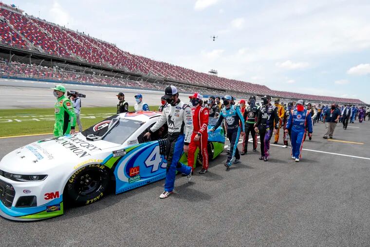 Nascar drivers Kyle Busch, left, and Corey LaJoie, right, led the entire garage in standing in solidarity with Bubba Wallace.