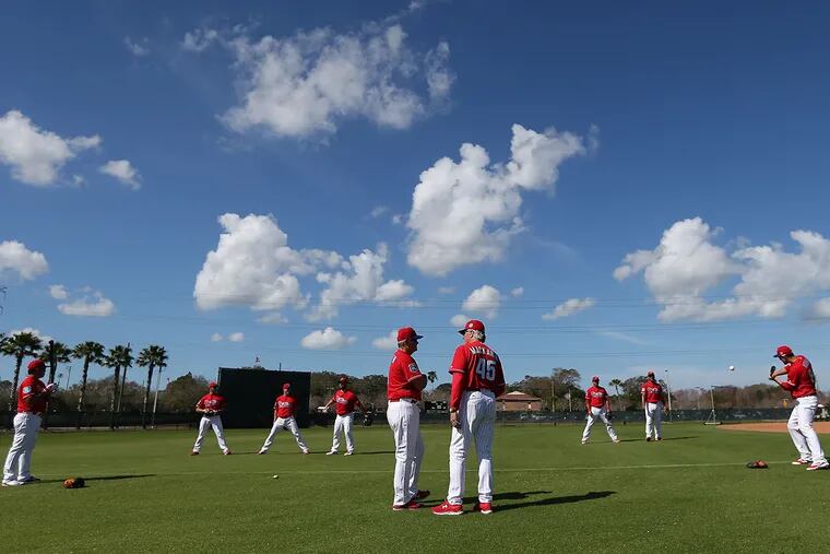 Manager Pete Mackanin (center, right) and John McLaren (center, left) watch as players play pepper during Phillies spring training in Clearwater, Fla. on Monday, Feb. 22, 2016.