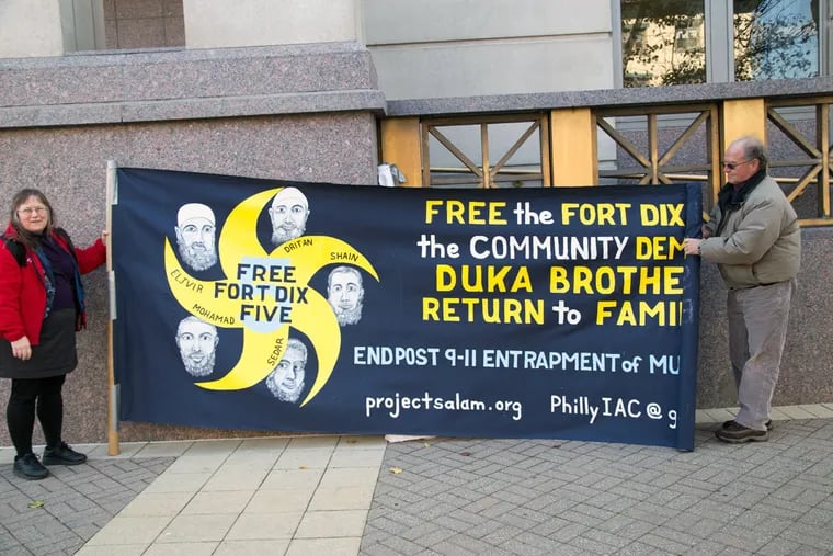 Protesters Lynne Jackson and Steve Downs unroll a banner in support of the Duka brothers outside the federal courthouse in Camden.