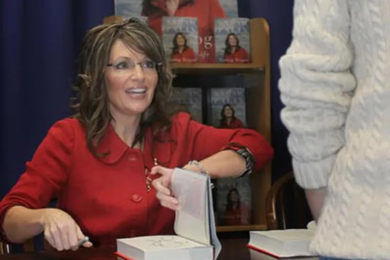 Former Alaska Gov. Sarah Palin signs a copy her autobiography, "Going Rogue", at Joseph-Beth Booksellers in in Norwood, Ohio, on Nov. 20, 2009. (AP Photo/Tom Uhlman)