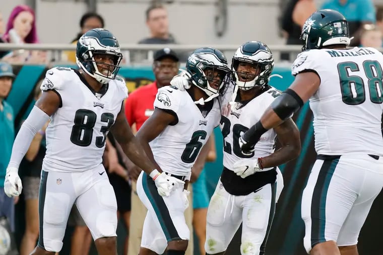 Eagles wide receiver Greg Ward  (second from left) celebrates his second-quarter touchdown pass with teammates tight end Josh Perkins (left), running back Miles Sanders (second right) and offensive tackle Jordan Mailata (right).