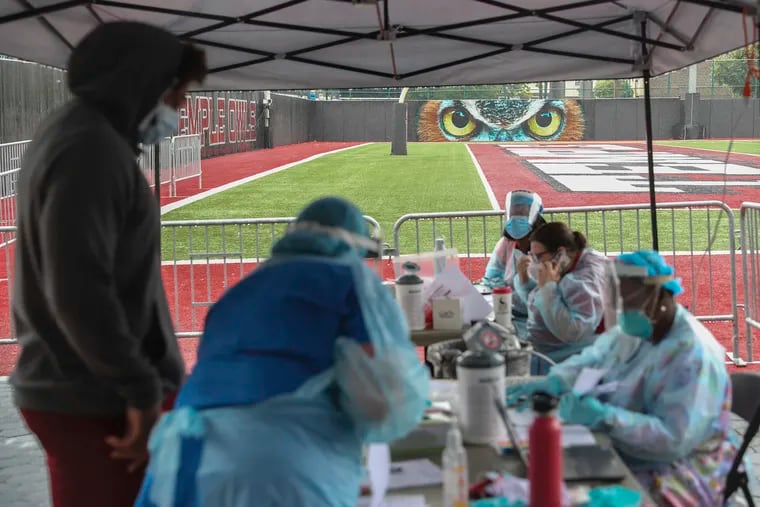 Healthcare workers administer coronavirus tests to members of the Temple football team outside of Edberg-Olson Hall on Thursday.