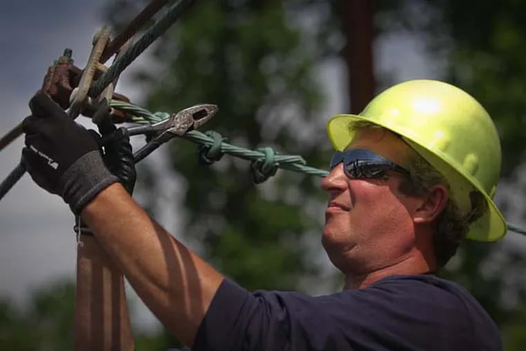 SEPTA lineman Lance Henry upgrades an overhead wire to cut train delays and improve performance. (ALEJANDRO A. ALVAREZ / Staff Photographer)