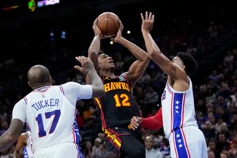 The Atlanta Hawks' De'Andre Hunter, center, going up for a shot against the Sixers' Tobias Harris, right, and P.J. Tucker during a game on Nov. 12.