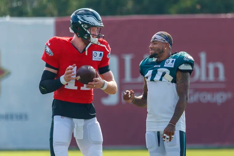 Eagle starting quarterback Carson Wentz, left, and wide receiver DeSean Jackson, right, share a moment between drills at training camp. The Eagles are 9-point favorites for their opener at home against Washington.