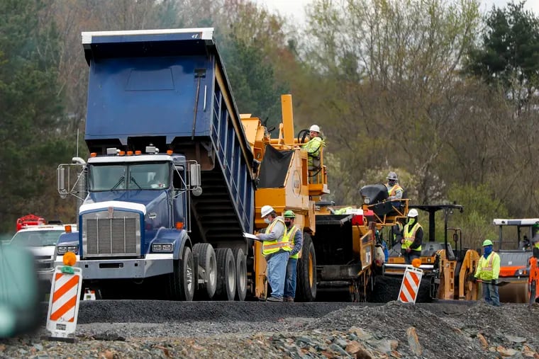 Workers lay a new stretch of asphalt as paving and construction resume on Interstate 79, Friday, May 1, 2020, in Cranberry Township, Pa. Work at the site halted in mid-March when the state ordered a stop to non-essential business to slow the spread of the new coronavirus.
