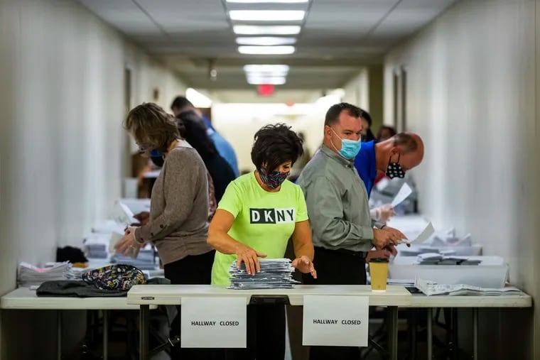 Jeri Shuits (center) office manager for the Beaver County Board of Elections, prepares ballots for counting in the basement of the Beaver County Courthouse on Wednesday in Beaver, Pa.