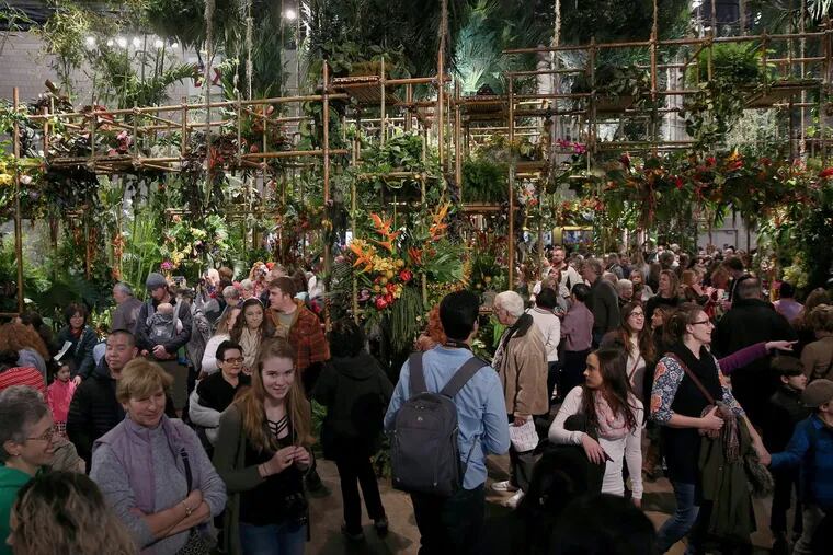 Attendees walk through a rainforest feature during the first day of the annual Philadelphia Flower Show at the Pennsylvania Convention Center on Saturday, March 3, 2018.