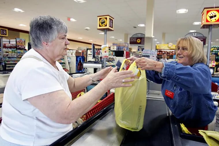 Cashier Helen Ladd (right) hands Carol Grochal of Marlton a bag of her groceries at the check out of the Shop Rite in Marlton, New Jersey on June 19, 2008. Shop Rite is gaining market share, our annual survey of the Philadelphia supermarket fields shows. Who's losing? And are the non-food stores, like Wal-Mart, still growing their share? (Barbara L. Johnston/Inquirer)