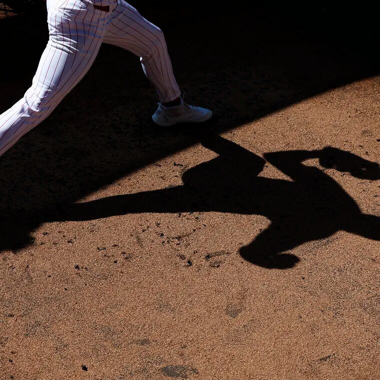 The shadow of Phillies pitcher Spencer Turnbull as he throws in the bullpen during spring training at the BayCare Ballpark in Clearwater, Fla. on Tuesday, Feb. 20, 2024.