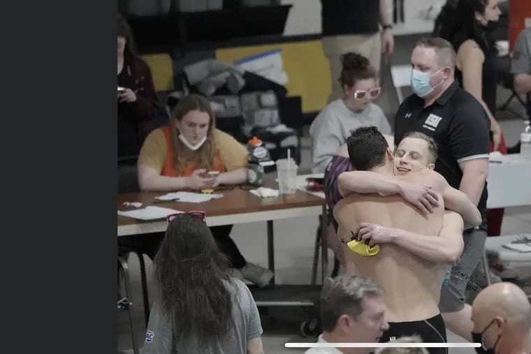Logan Brockway embraces Stephen Dow (facing camera) after Dow won the 200-yard breaststroke at the PSAC Championships.