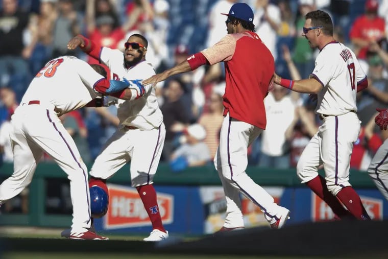 Phillies outfielder Aaron Altherr (left) is congratulated by Carlos Santana, and teammates after winning the game with an RBI single in the 11th inning against the Pirates at Citizens Bank Park.