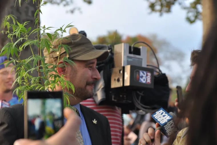 Chris Goldstein poses with a homegrown marijuana plant.