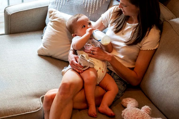 Liz Lockerman feeds her 8 month-old son, Logan, a bottle of infant formula at home May 31, 2022. The infant formula shortage has exacerbated the stigma parents feel when they don't breastfeed.