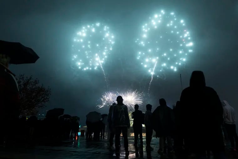 People watch the Rivers Casino New Year’s Eve fireworks show on the waterfront in Philadelphia on Dec. 31, 2022.