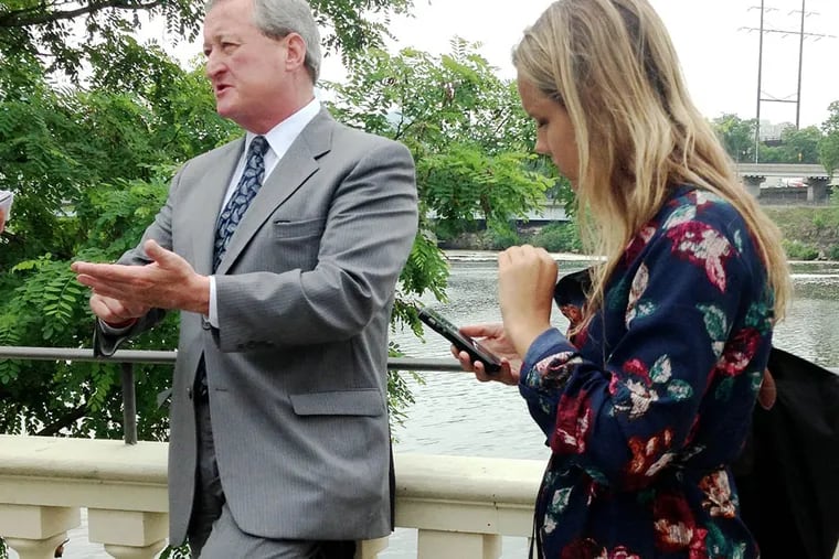 Democratic mayoral pick Jim Kenney fields questions from a reporter after a press conference to promote clean water with Lauren Hitt, his campaign spokeswoman, at his arm. ( Wendy Ruderman / Daily News Staff )
