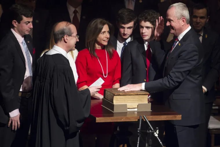 Democrat Phil Murphy, right, raises his hand as he takes the Oath of Office administered by State Supreme Court Chief of Justice, Stuart Rabner, during the 56th Governor of New Jersey Swearing In Ceremony. Tuesday, January 16, 2018. Murphy’s wife and four children joined him as he took the oath Tuesday on the same Bible that John F. Kennedy used when he was sworn in as president.