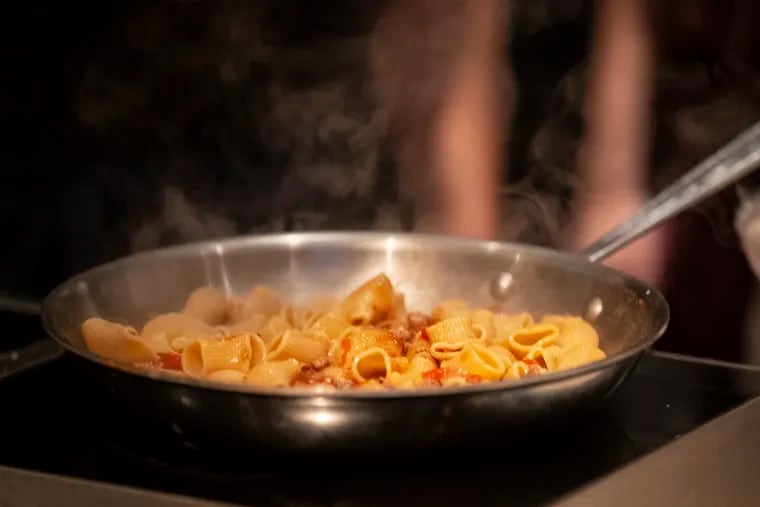 A pan of rigatoni with Fiorella sausage ragu cooks during the preview of Marc Vetri's 14-seat Italian Market pasta bar Fiorella, that was held at the Fitler Club.