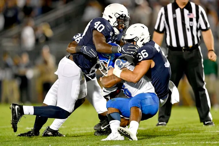 Penn State linebackers Jesse Luketa and Jan Johnson pull down Buffalo's Jaret Patterson  in September 2019.  Luketa is one of the three linebackers who will be stepping into the starting roles left behind by Johnson, Cam Brown, and Micah Parsons. 



(Abby Drey/Centre Daily Times/TNS)