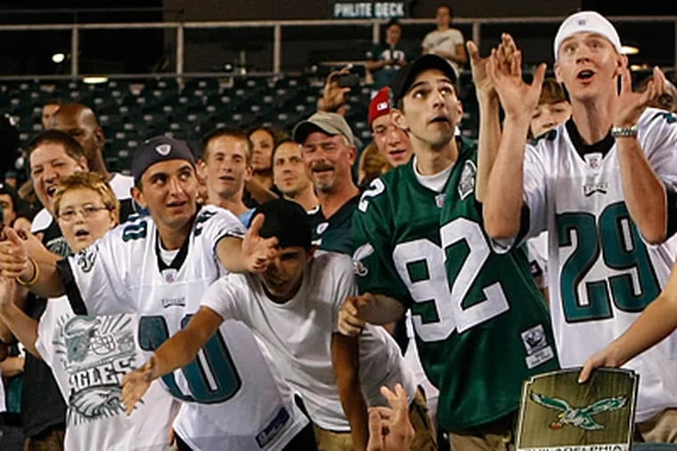 Eagles fans crowd the rail as Kevin Kolb walks by below them. (Ron Cortes / Staff Photographer)