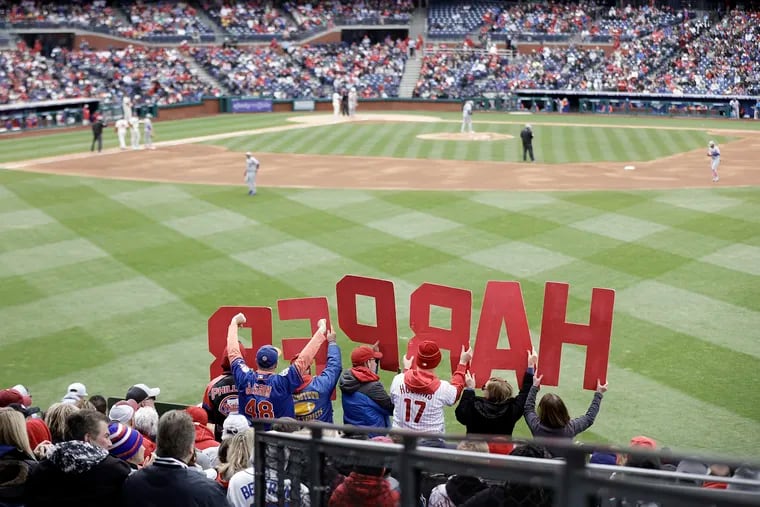 Fans hold up letters spelling HARPER as Bryce Harper comes to bat during the first game of a doubleheader against the New York Mets.