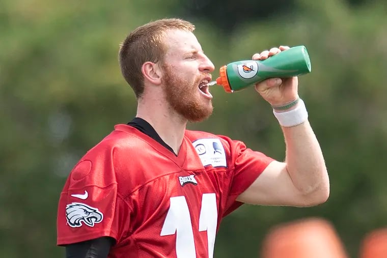 Eagles quarterback Carson Wentz cools off  during practice Tuesday. It's still not certain whether he'll play at all in Thursday's first preseason game.