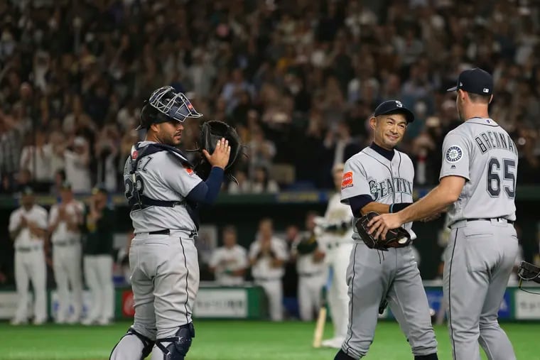 Mariners right fielder Ichiro Suzuki, second from right, is applauded by teammates Brandon Brennan (65), catcher Omar Narvaez after leaving the second game of their series last week in Tokyo. Seattle won, but it wasn't a victory for everyone.