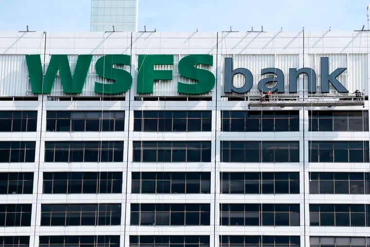 Workers secure the new WSFS Bank sign to the south side of 1818 Market St, Phila., Pa. on August 4, 2019.