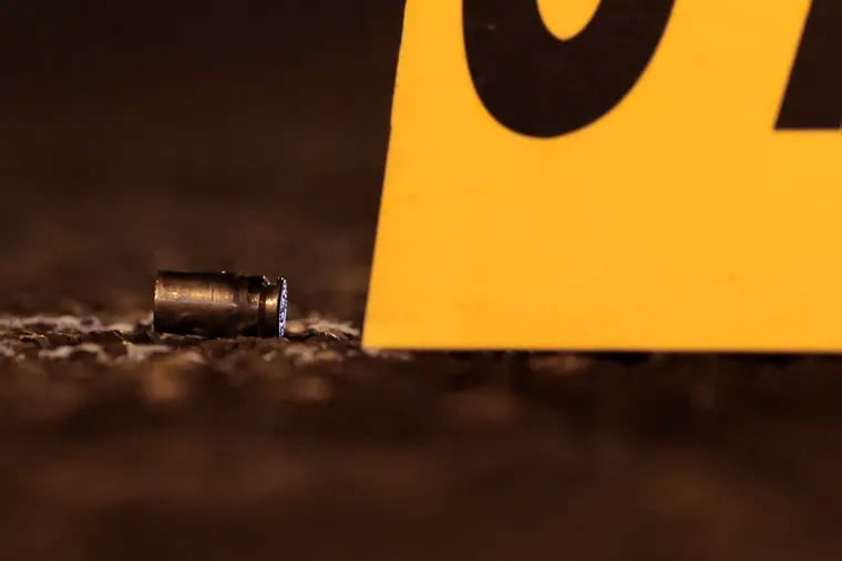 A bullet casing circled and marked by an evidence marker.