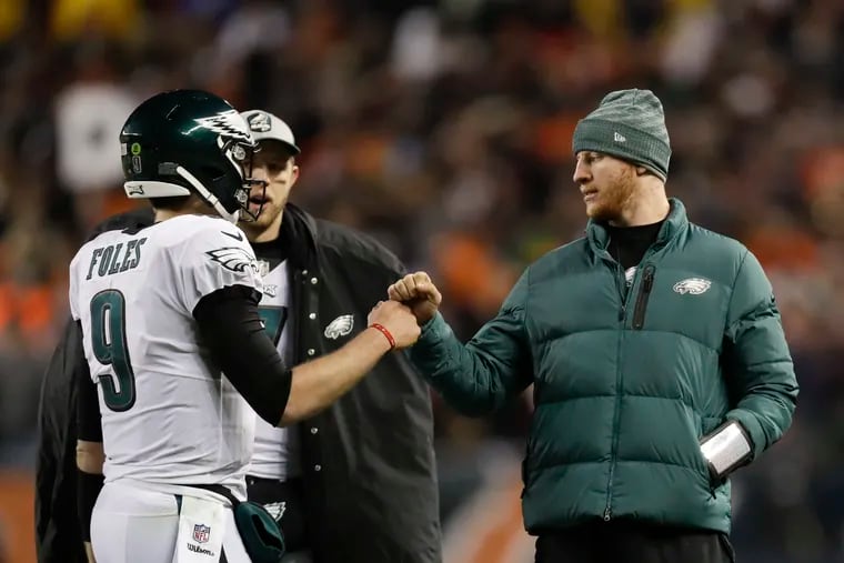 Eagles quarterbacks Nick Foles and Carson Wentz fist-bump during a break in last year's NFC wild-card win over the Chicago Bears.