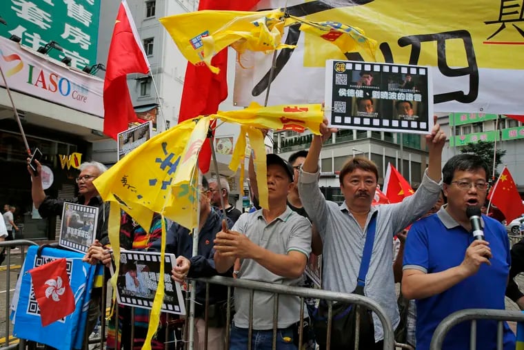 Pro-Beijing supporters destroy yellow umbrellas, used to mark protesting denouncing far-reaching Beijing control, during a demonstration in Hong Kong, Sunday, May 26, 2019. A vigil will be held on June 4 at the Victoria Park to mark the 30th anniversary of the military crackdown on the pro-democracy movement at Beijing's Tiananmen Square on June 4, 1989. (AP Photo/Kin Cheung)