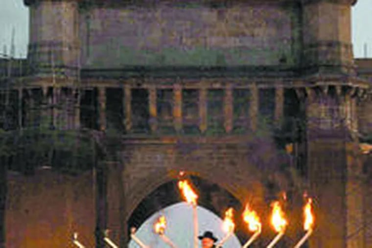 Rabbi Shimon Rosenberg , father of Mumbai victim Rivka Holtzberg, lights a 16-foot menorah in the Indian city.