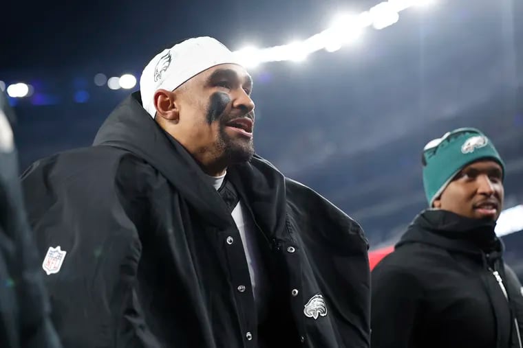 Eagles quarterback Jalen Hurts and offensive coordinator Brian Johnson walk off the field after losing to the Giants on Sunday.