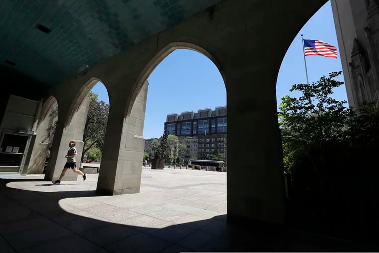 A runner passes through an arch on the campus of Boston University on May 20, 2020. COVID-19 has disrupted the plans of an estimated 3 million returning college students.
