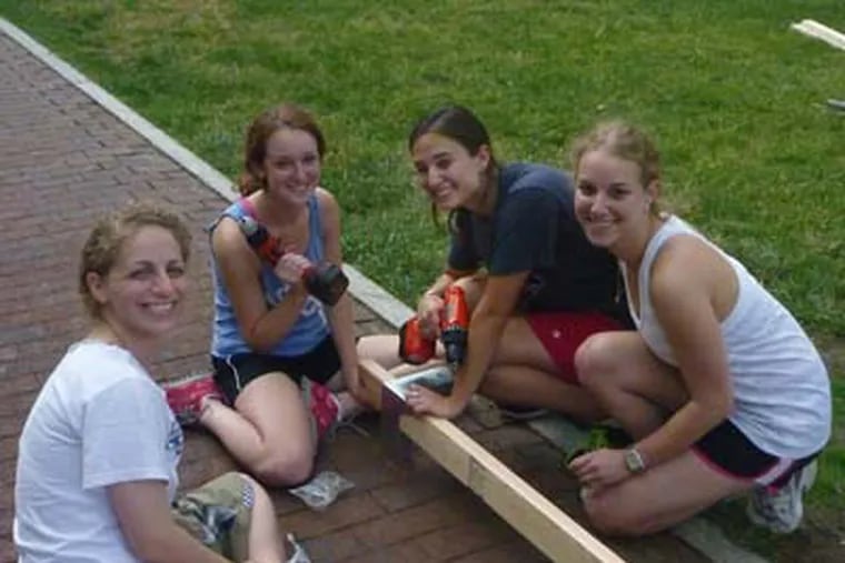 At the University of Pennsylvania campus, sukkathon project coordinator Naomi Hachen, far left, works at building a sukka with team Wear-Care.  Second from left is Jessica Marder; third from left is Melissa Goldstein, name of fourth girl is Aliza Keller.  Photo by Joe Trinacria