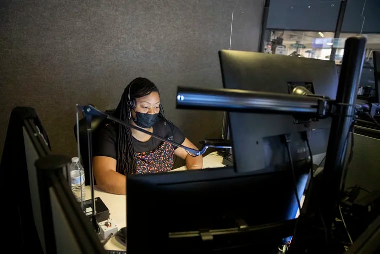 Ebony Faulk, a forensic behavioral health navigator, works in the police radio room at the Philadelphia Police Department headquarters on Monday.