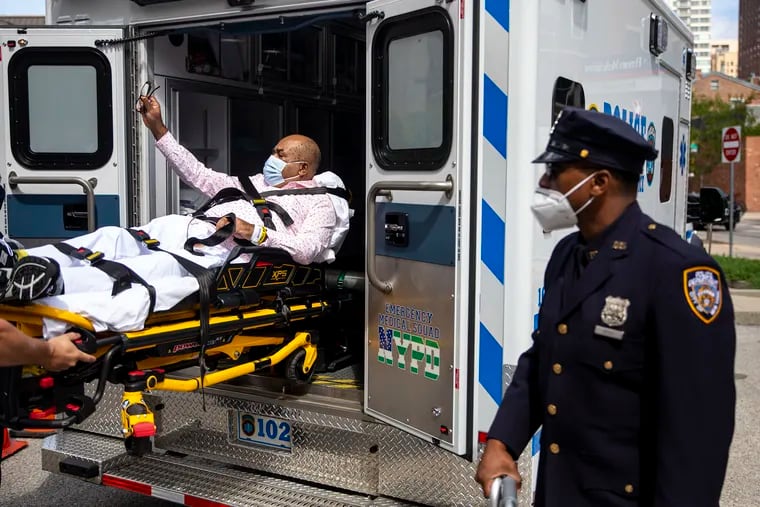 Yvan Pierrelouis, 59, of Long Island, N.Y., is being loaded Saturday into an ambulance as his son, Ralph Remy, a fellow NYPD officer watches. The elder Pierrelouis was released from Good Shepard rehab in Center City after five and a half months of fighting COVID-19.