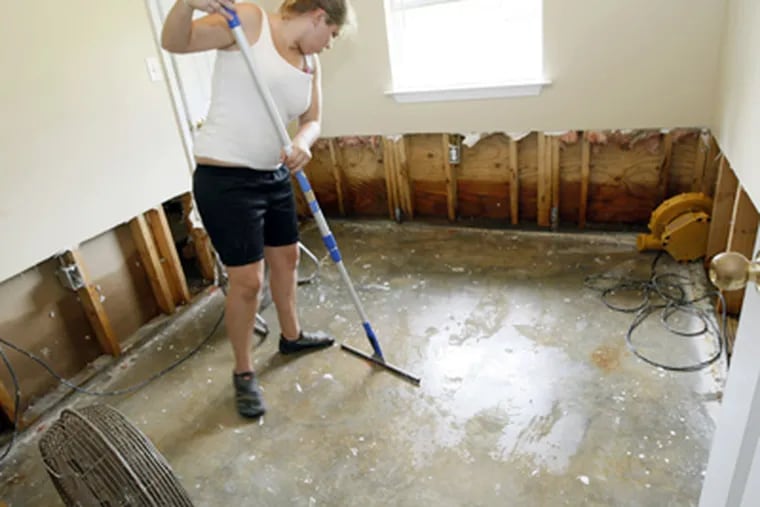 Kayrin White wipes down a bedroom floor in her parents' home in Bay St. Louis, Miss., in the aftermath of Isaac. The house took in almost two feet of water. (Rogelio V. Solis / Associated Press)